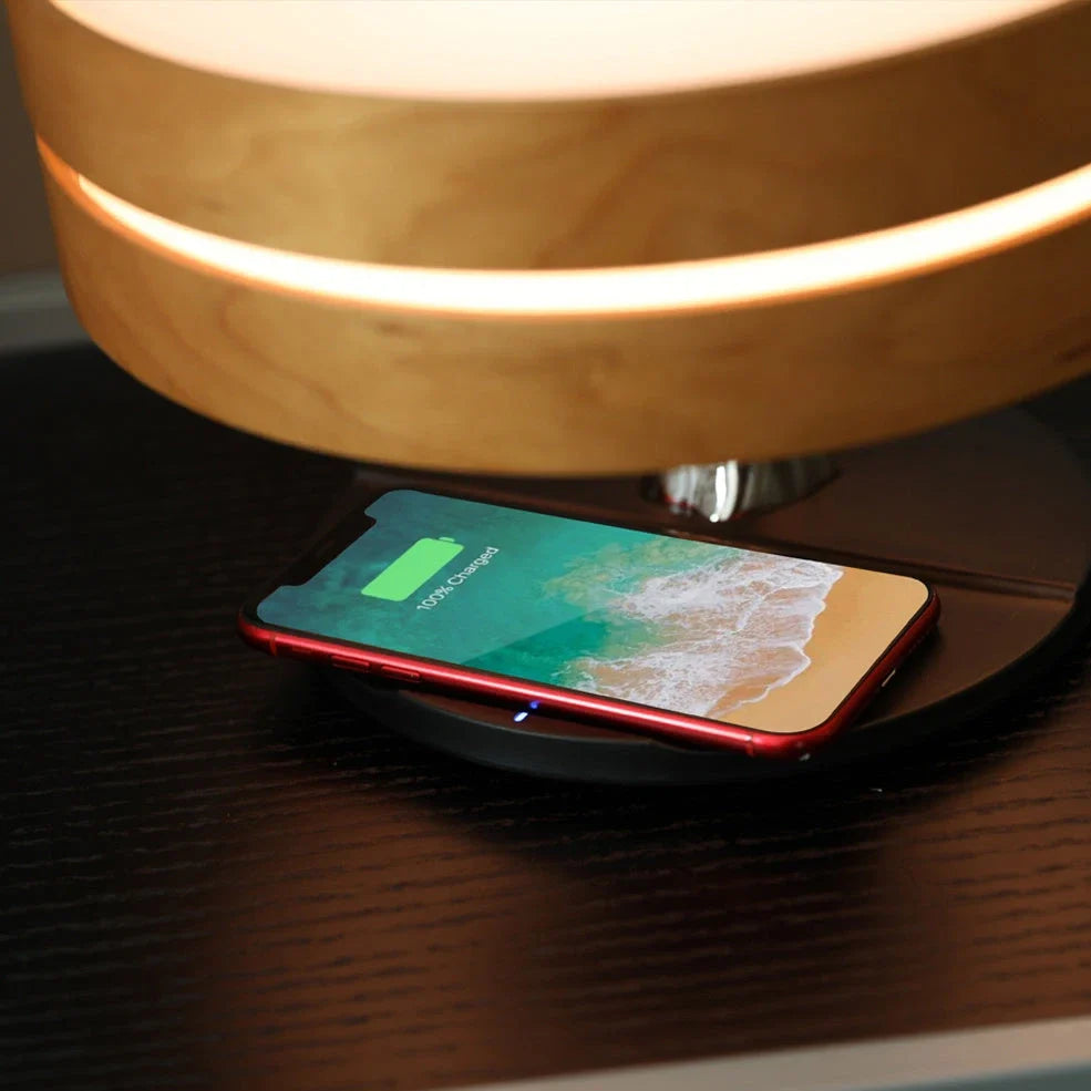 Round Bluetooth speaker with LED tree lighting and wireless charging surface in maple brown finish