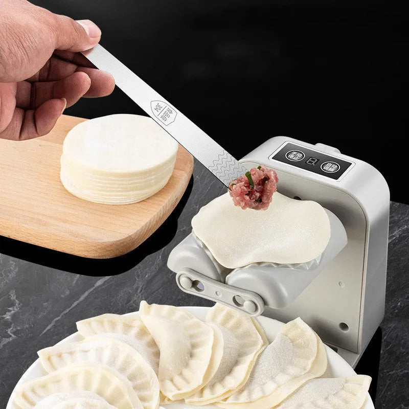 White automatic electric dumpling maker machine with USB cable, brush, and spoon.