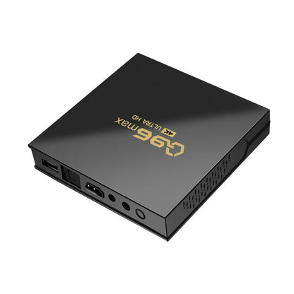 Q96 MAX Android TV set-top box with remote control and HDMI cable on a wooden surface.