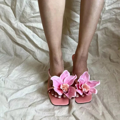 Pink women's flip-flop sandals with artificial Phalaenopsis orchid flower and square-toe design