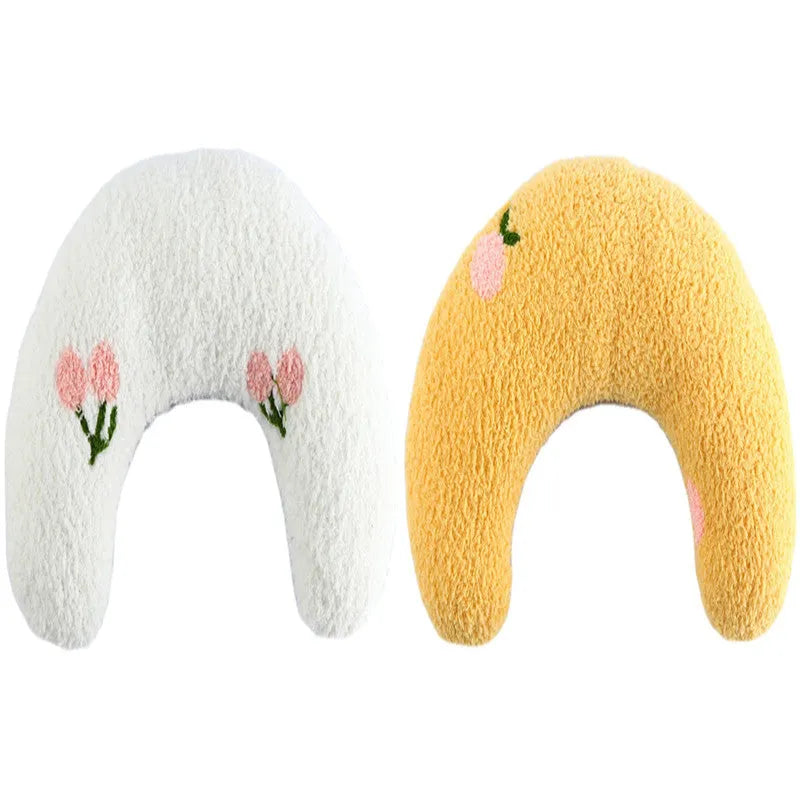 White U-shaped pet pillow measuring 27cm with raised rim supporting small cat's neck and back