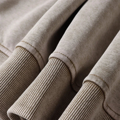 A brown cotton pullover hoodie with an embroidered letter patch design, perfect for casual and comfortable fall fashion.