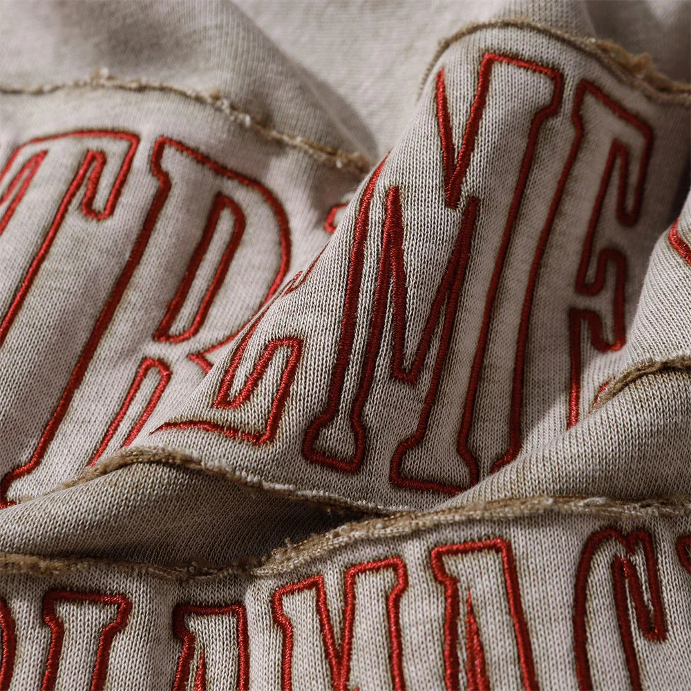 A brown cotton pullover hoodie with an embroidered letter patch design, perfect for casual and comfortable fall fashion.