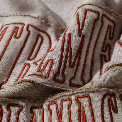 A brown cotton pullover hoodie with an embroidered letter patch design, perfect for casual and comfortable fall fashion.