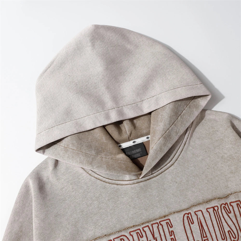 A brown cotton pullover hoodie with an embroidered letter patch design, perfect for casual and comfortable fall fashion.