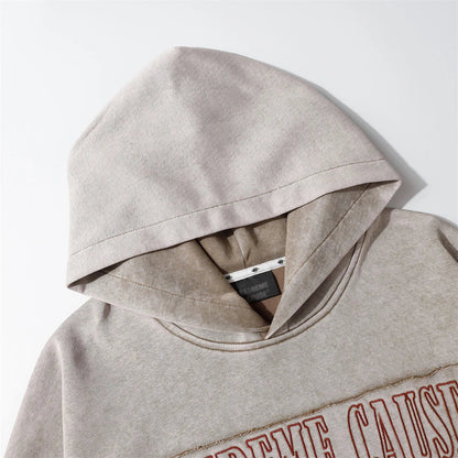 A brown cotton pullover hoodie with an embroidered letter patch design, perfect for casual and comfortable fall fashion.