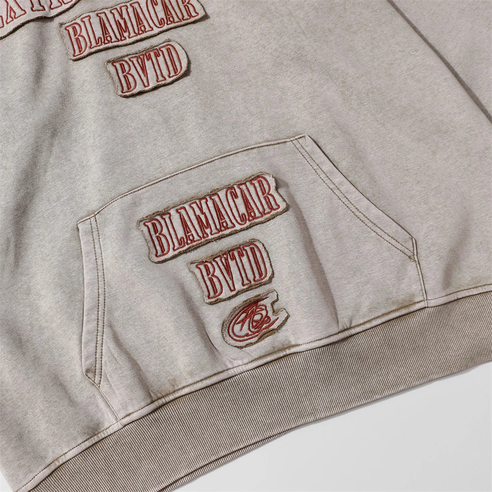 A brown cotton pullover hoodie with an embroidered letter patch design, perfect for casual and comfortable fall fashion.