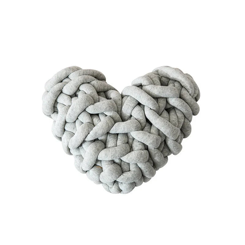 Heart-shaped decorative knot cushion in light gray color, fluffy and textured for cozy home decor
