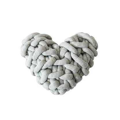 Heart-shaped decorative knot cushion in light gray color, fluffy and textured for cozy home decor
