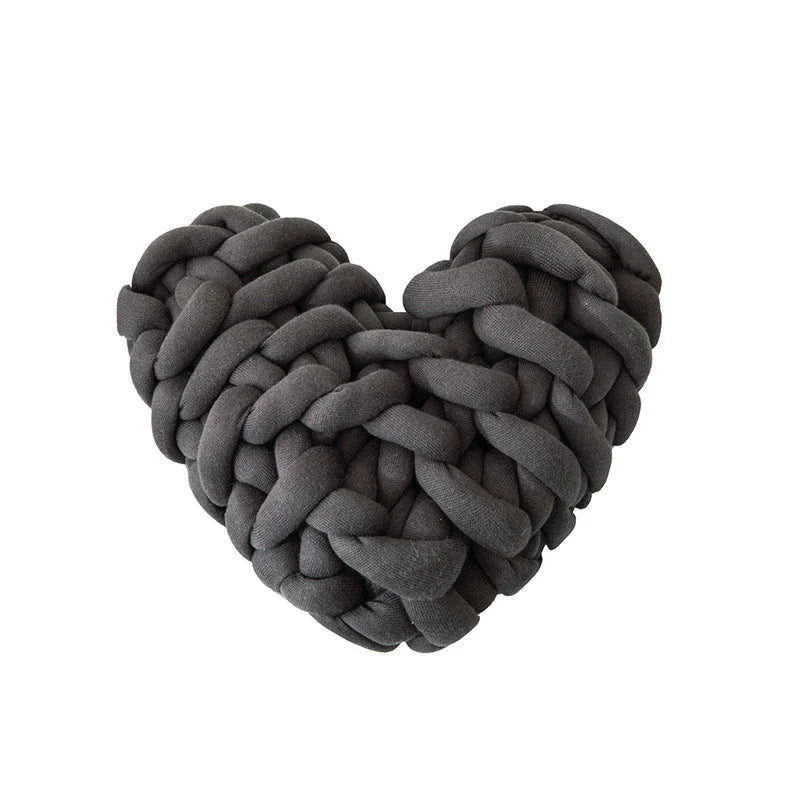 Heart-shaped decorative knot cushion in light gray color, fluffy and textured for cozy home decor