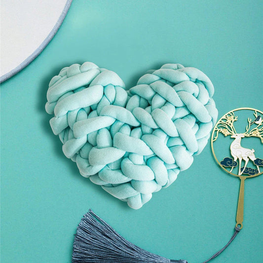Heart-shaped decorative knot cushion in light gray color, fluffy and textured for cozy home decor