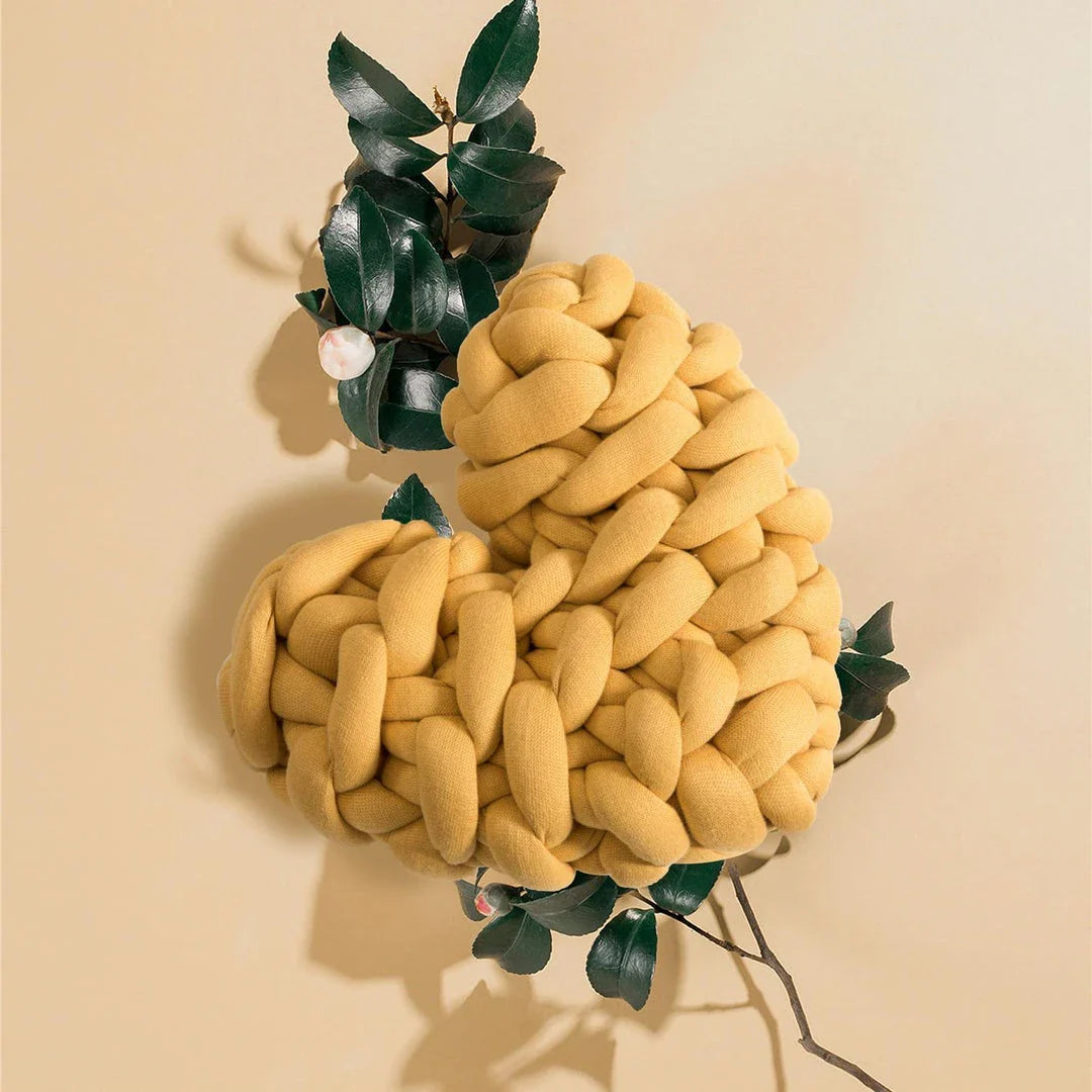 Heart-shaped decorative knot cushion in light gray color, fluffy and textured for cozy home decor