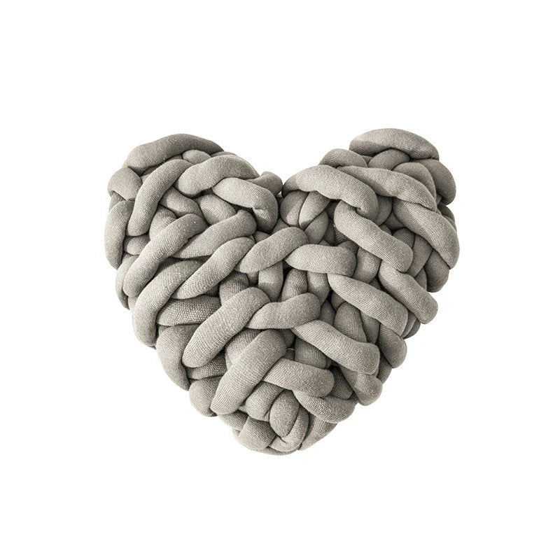 Heart-shaped decorative knot cushion in light gray color, fluffy and textured for cozy home decor