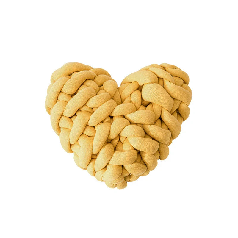 Heart-shaped decorative knot cushion in light gray color, fluffy and textured for cozy home decor