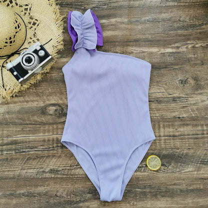 A woman's solid colour one-piece swimsuit with a single-shoulder suspender tube top design.