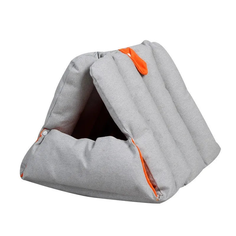 Blue triangular cotton cat bed with a removable cover on a wooden floor.