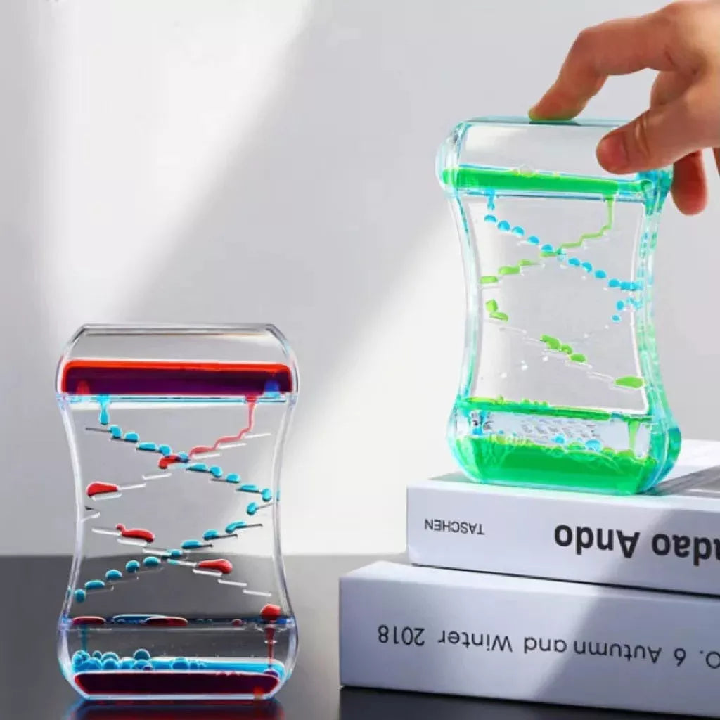 Creative Cruise Fluid Liquid Hourglass Timer with blue and pink liquid on desk