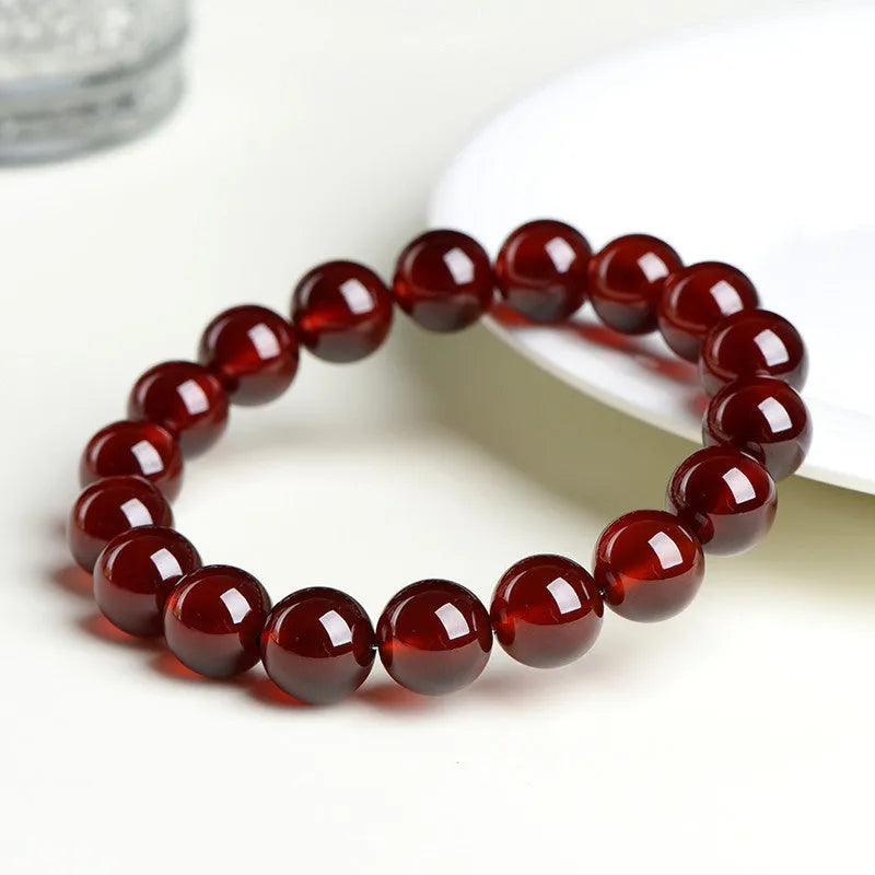 Natural orange red garnet crystal ball bracelet with traditional Ruyi design elements and adjustable bead sizing