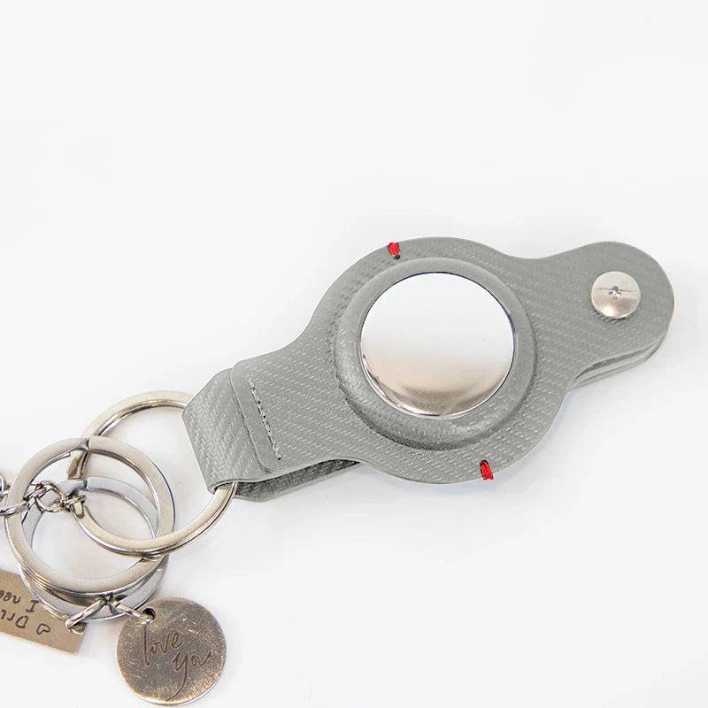 Stylish and secure AirTag holder keychain in black and grey PU leather, with a sturdy key ring for attaching to valuables