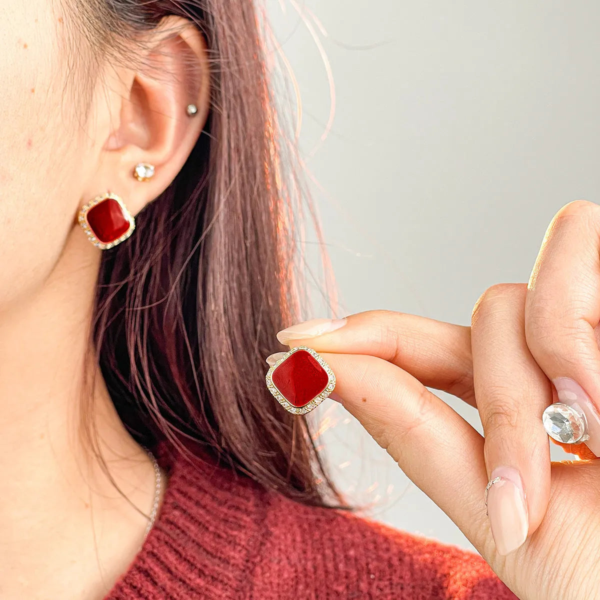 Red square alloy earrings with an inlaid geometric design, shown from the front.