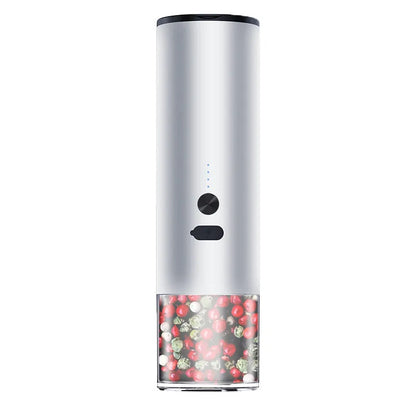 White electric salt and pepper grinder with stainless steel top and clear glass jar on a kitchen counter.