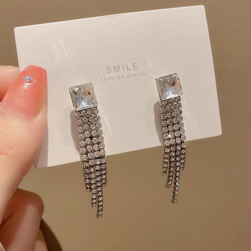 Sparkling zircon tassel earrings in sterling silver, featuring dazzling gems and flowing tassels for a bold, fashionable look.