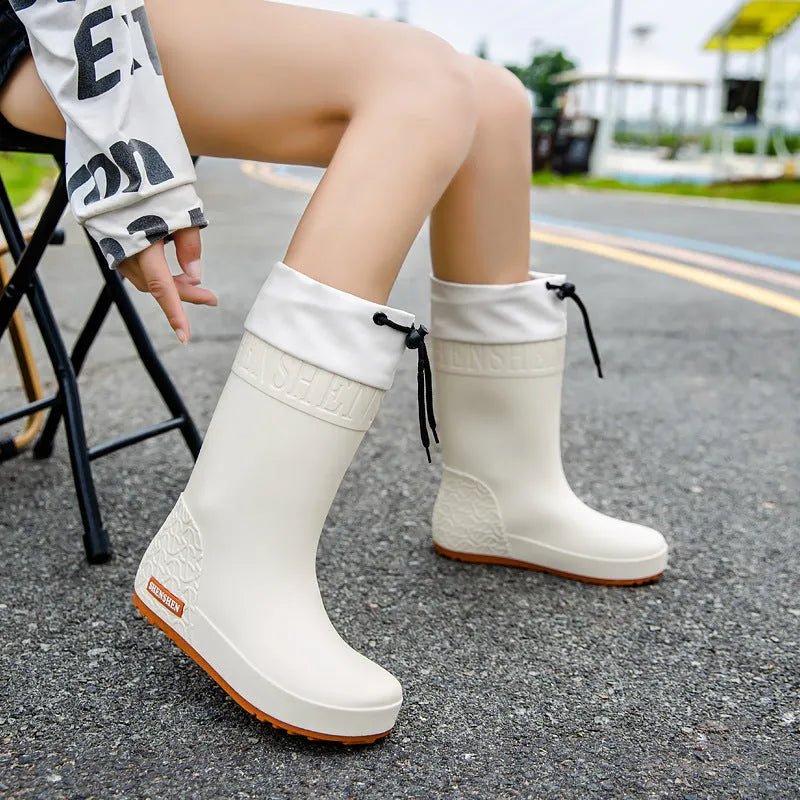Women's solid colour PVC rain boots with non-slip soles in apricot, black, brown, or pink