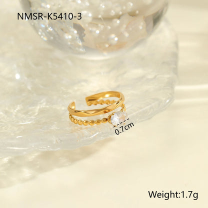 Gold electroplated stainless steel open mouth ring with geometric shapes and zircon inlay on a heart drop.