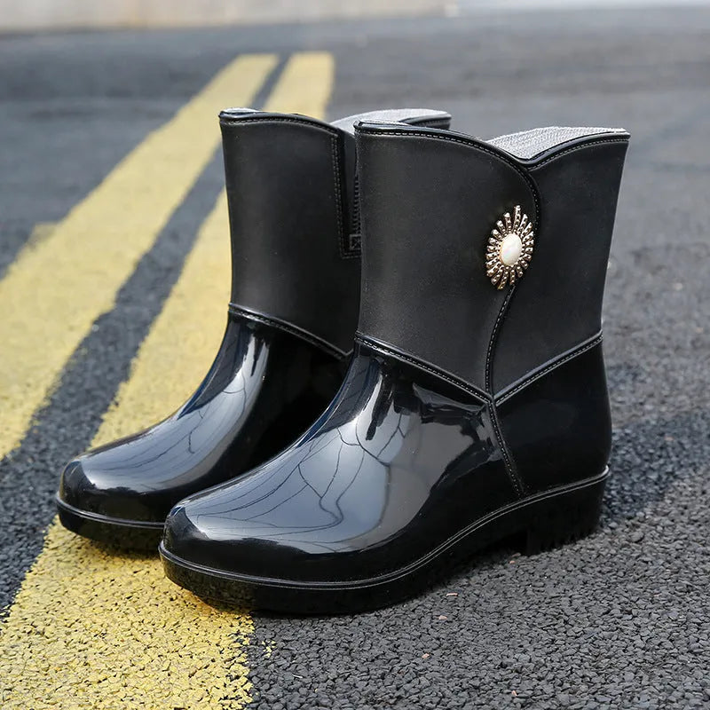 Women's purple PVC rain boot with non-slip sole on a wet surface.
