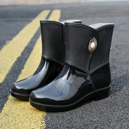 Women's purple PVC rain boot with non-slip sole on a wet surface.