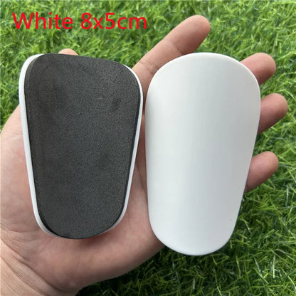 Extra small plastic football shin guards in black and white colours for youth players