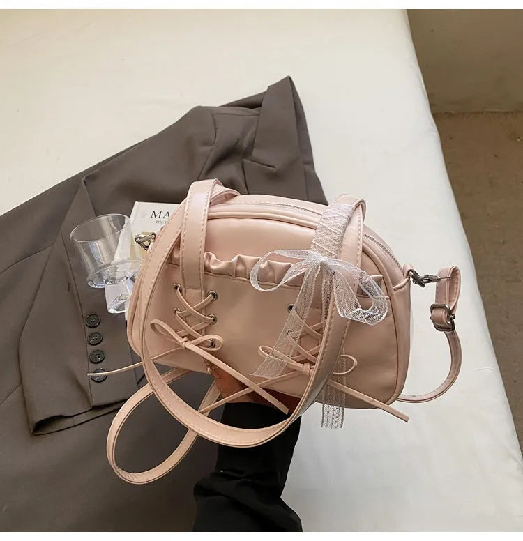 Milky white women's shoulder handbag with a large bandage bow and visible stitching, showing the internal phone pocket.