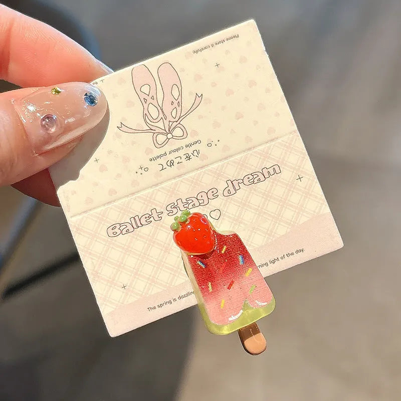 A resin hair barrette with a cartoon ice cream charm on a side-clip, shown in a pink colour variant.