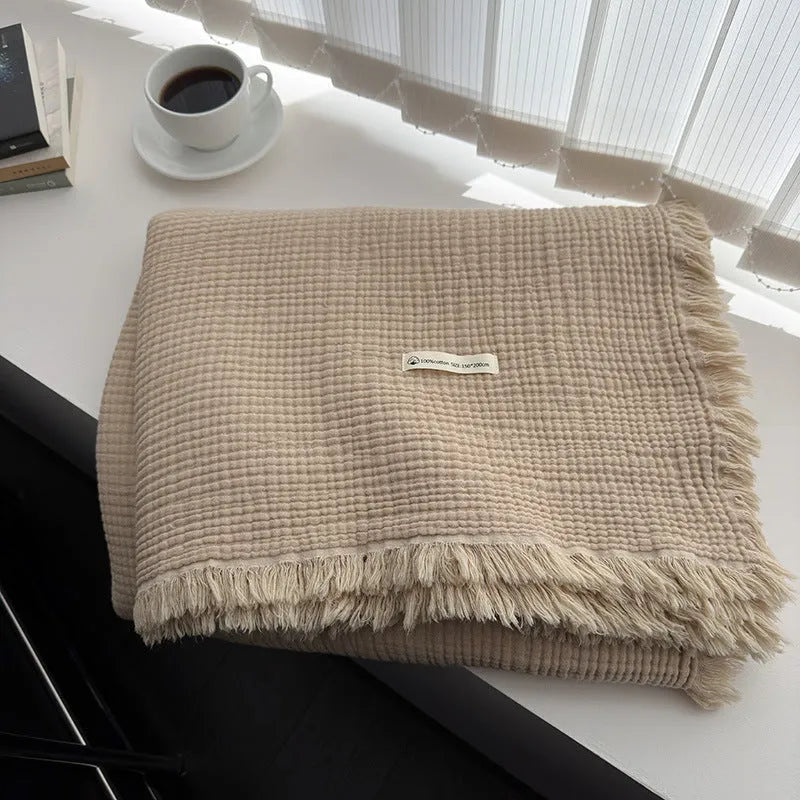Four-layer gauze tassel blanket in cotton, showing tassel edges and textured fabric, available in multiple colours and sizes