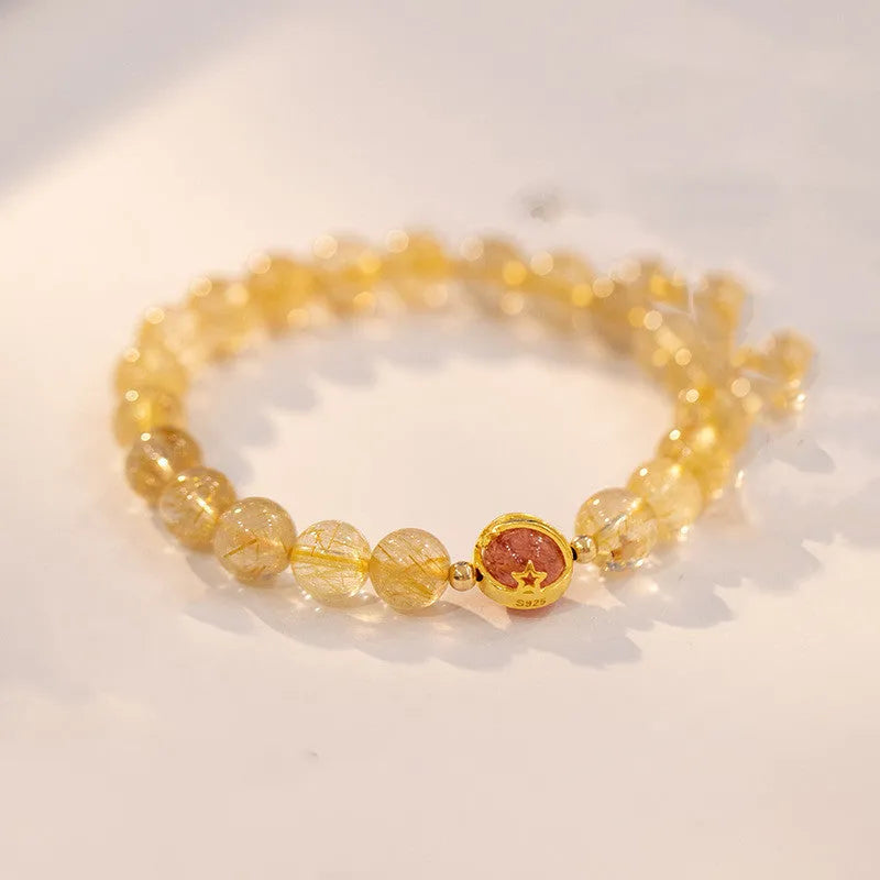 Citrine and gold rutilated quartz stretch bracelet with diamond-cut beads on an elastic band.