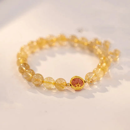 Citrine and gold rutilated quartz stretch bracelet with diamond-cut beads on an elastic band.