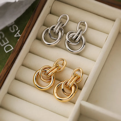 Geometric gold-coloured copper earrings with irregular asymmetric design
