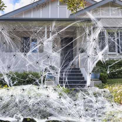 White cotton spider web Halloween decoration with multiple spiders draped over furniture for spooky atmospheric display