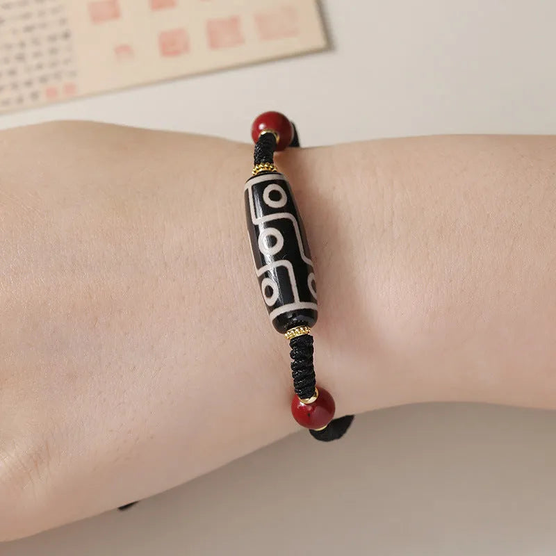 Men's adjustable agate dzi bead bracelet with traditional symbols on a shrinkable band.