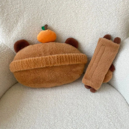Khaki capybara car pillow in artificial plush with synthetic fibre filling, shown as a car neck pillow or shoulder cover.