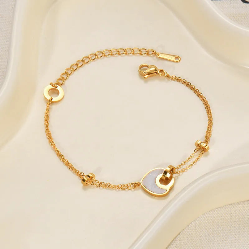 Stainless steel bracelet with double-layer heart design containing resin elements, shown on wrist