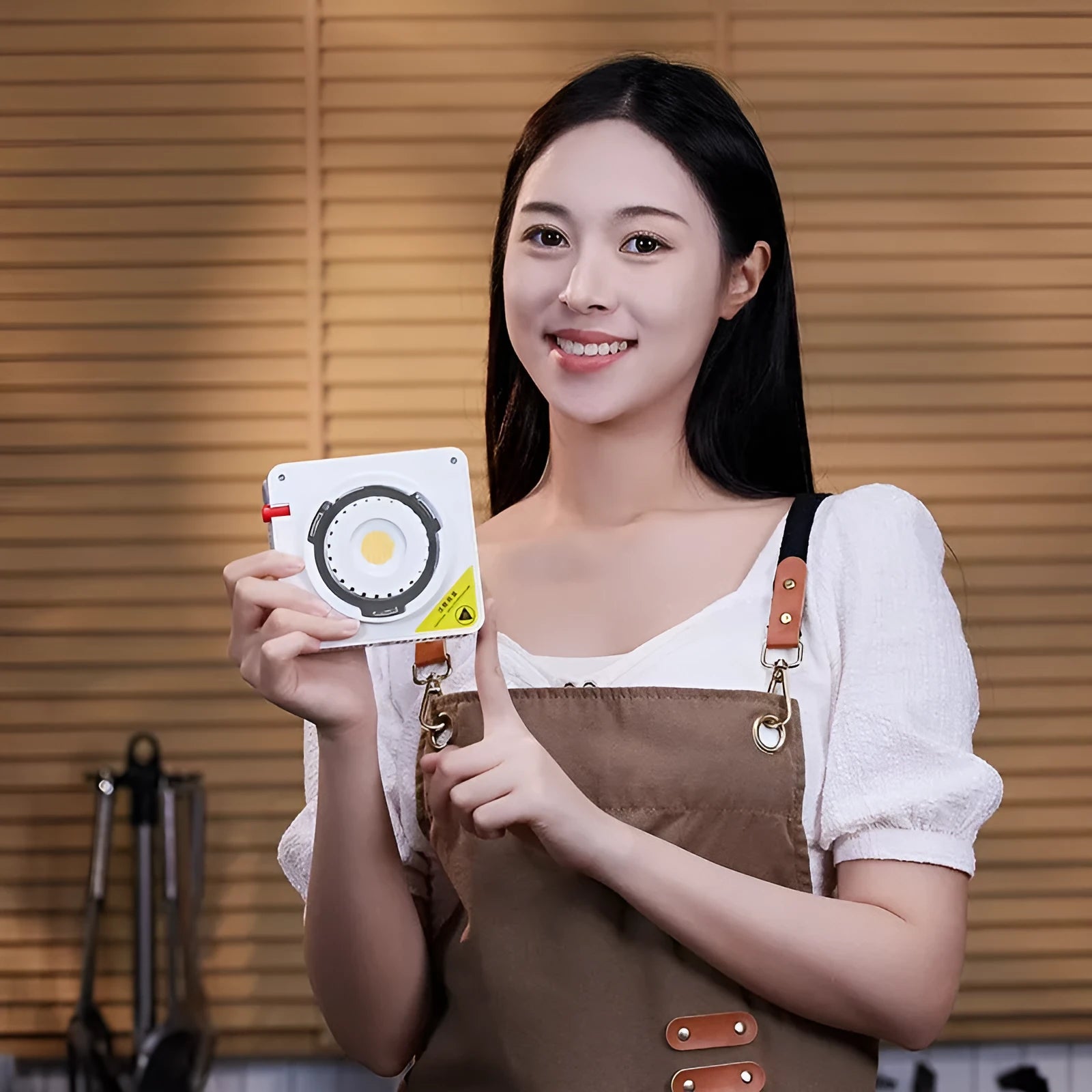 Shenniu ML100Bi 200W LED photography fill light with lenses, battery handle, and accessories on a studio table.