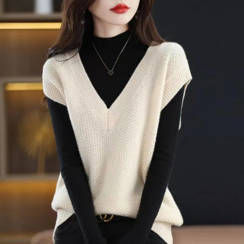 Women's creamy-white sleeveless knit vest with a raised 3D pattern, shown on a hanger.
