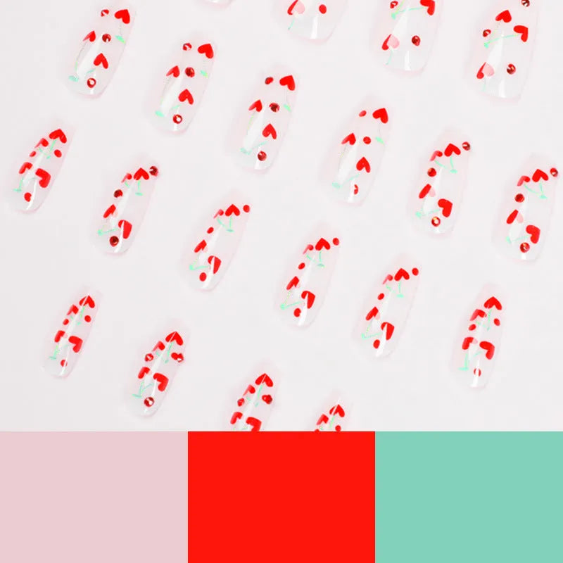 Sheet of 24 red diamond and cherry patterned nail art stickers with a small tube of adhesive glue.