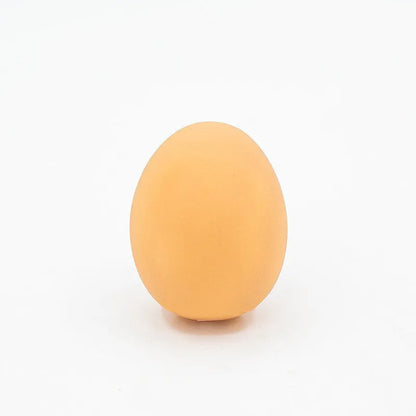 Pink rubber simulation egg dog toy with a textured surface for chewing.
