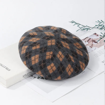Wool plaid beret with dome crown, adjustable size, and tassel and mesh detail in blue light coffee plaid.