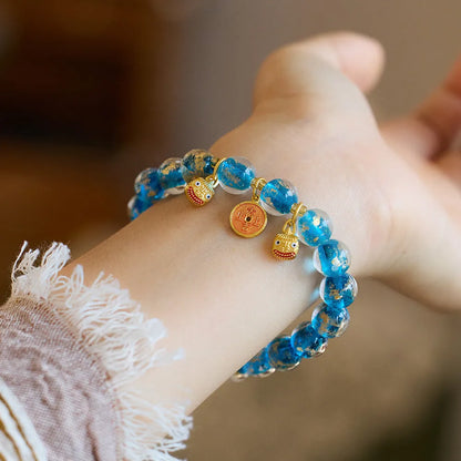 Handmade national style bracelet with coloured glaze swallowing gold beast charm on beaded band.