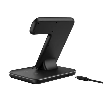 White three-in-one wireless charging stand for mobile phone, watch, and headphones on a desk.