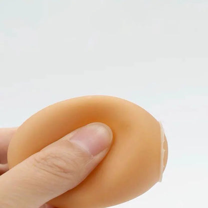 Pink rubber simulation egg dog toy with a textured surface for chewing.