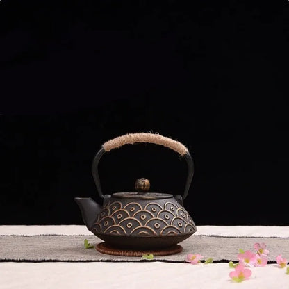 Japanese-style cast iron teapot with lid on a hob, shown in a bronze finish.